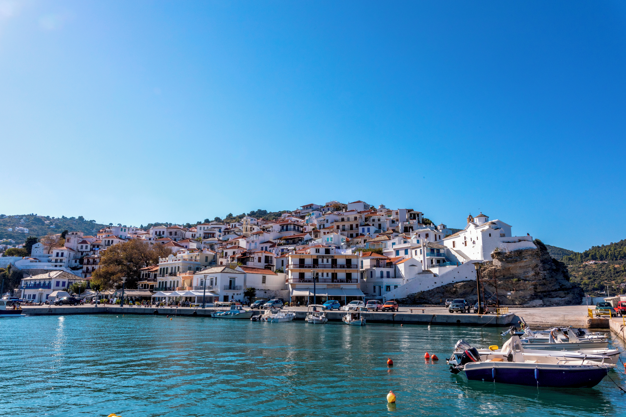 Scenic view of Skopelos Town with its traditional white houses and red roofs against a clear blue sky.