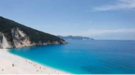 A beach with blue water and hills AI-generated content may be incorrect.