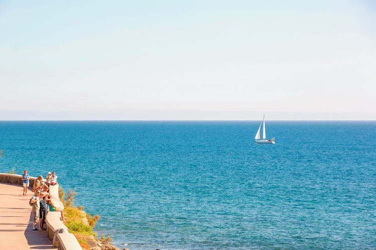A sailing boat glides over a calm blue sea in Meloneras.