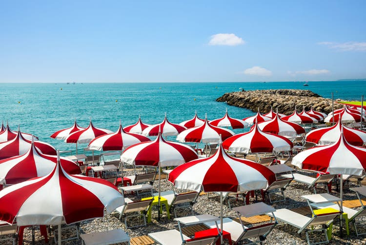 Cagnes-sur-Mer (Alpes-Maritimes, Provence-Alpes-Cote d'Azur, France), red and white umbrellas on the beach
