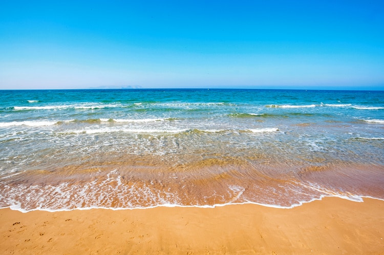 Clear blue sea gently lapping at sandy shores in Gouves.