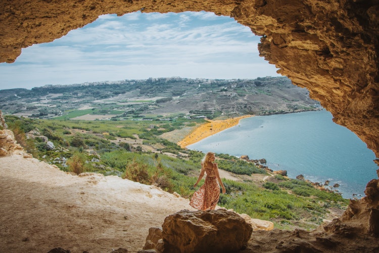 The stunning shoreline of Gozo, where the sea meets the land. Sandy beach, turquoise waters and lush green hills.