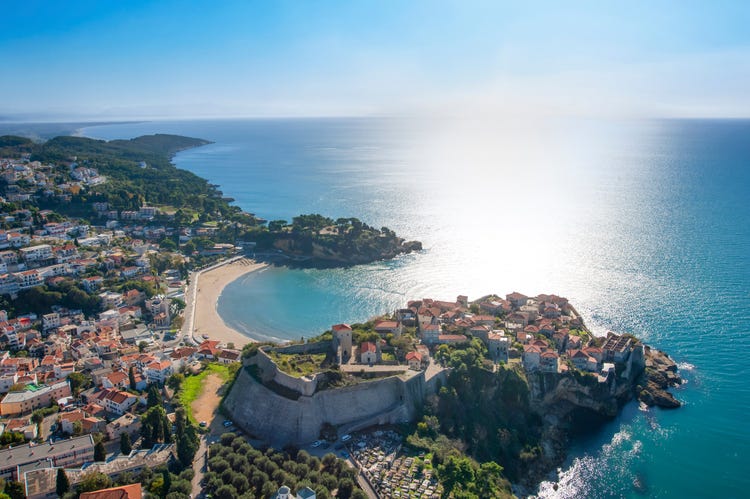 A stunning panorama of Ulcinj's beaches in Montenegro, with traditional houses dotting the vibrant coastal landscape.
