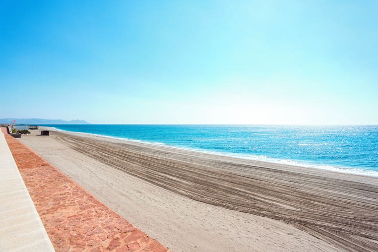 Tranquil beach view at El Toyo, featuring soft sand and serene blue waters under a clear sky.