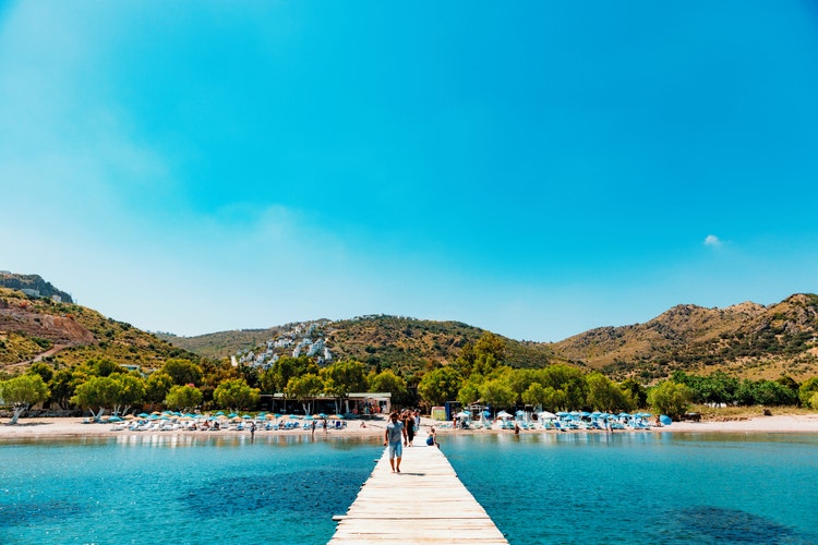 Panoramic view of Bodrum Resort featuring lush hills under a clear blue sky, with white buildings dotting the landscape.