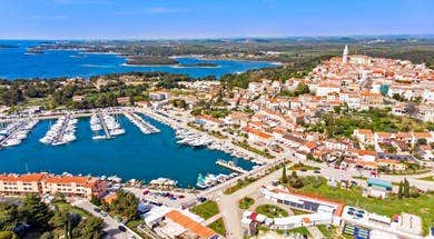 Colourful coastal town with terracotta roofs beside clear Adriatic water and harbour, Vrsar, Pula and Istrian Coast, Croatia.